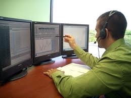 a forex retail trader in front of screens