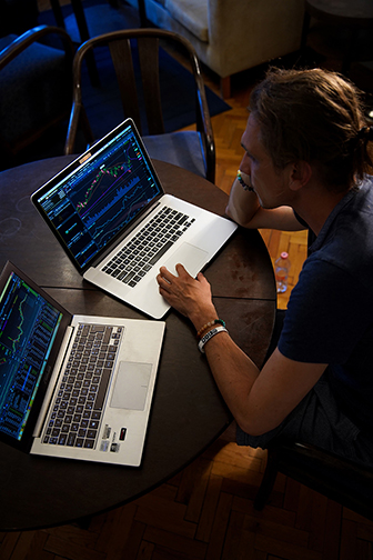 a forex trader studying a chart using both manual and automated hybrid trading