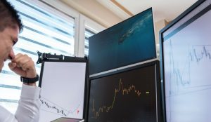 trader analyzing a screen with forex charting